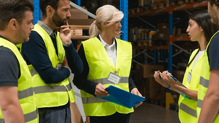Visual representation of a manufacturing shop floor with workers engaged in production scheduling, highlighting the importance of efficient scheduling processes for productivity.