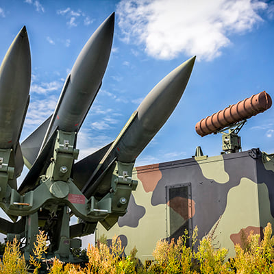 An image of an artistic sculpture or depiction of missiles in readiness that is outside a missile manufacturing plant.