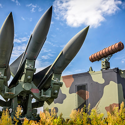 An artistic sculpture or depiction of missiles in readiness that is outside a missile manufacturing plant.
