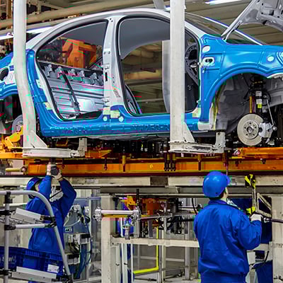 Photograph of a line worker performing assembly in an automotive manufacturing plant.