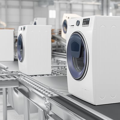 Photograph of washing machines on a production line in a manufacturing production plant.