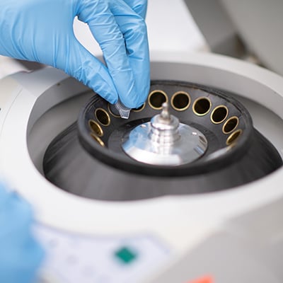 A manufactured centrifuge in use in a medical testing facility.