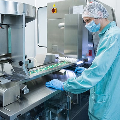 Photograph of production line operator in a pharmaceutical plant.