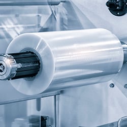 Photograph of a production line producing plastic film.