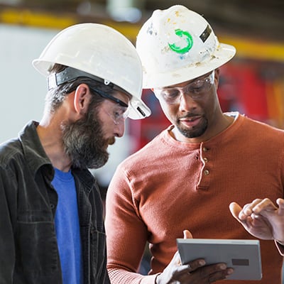 Two production specialists checking OEE in the plastics manufacturing plant.