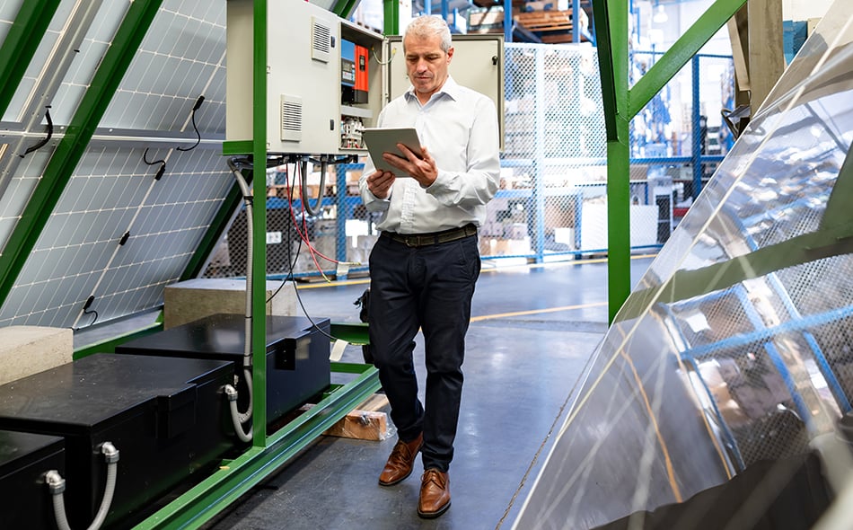 A business leader using a tablet device to access a supply chain system that has been integrated with the MES.