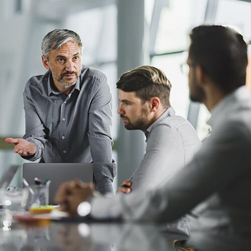 Three businessmen having a difficult discussion about outdated change management strategy