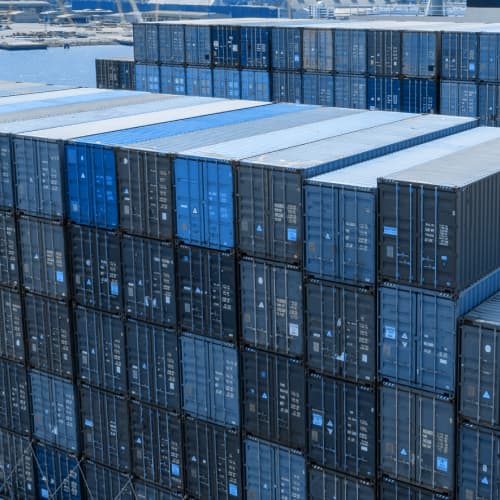 Rows of stacked shipping containers in a port.